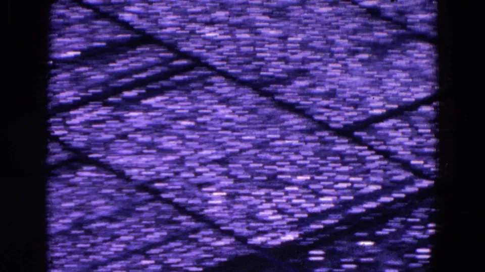 A close-up view from the 1967 clip shows a dark gridded or textured surface with strong purple-blue film color shift.