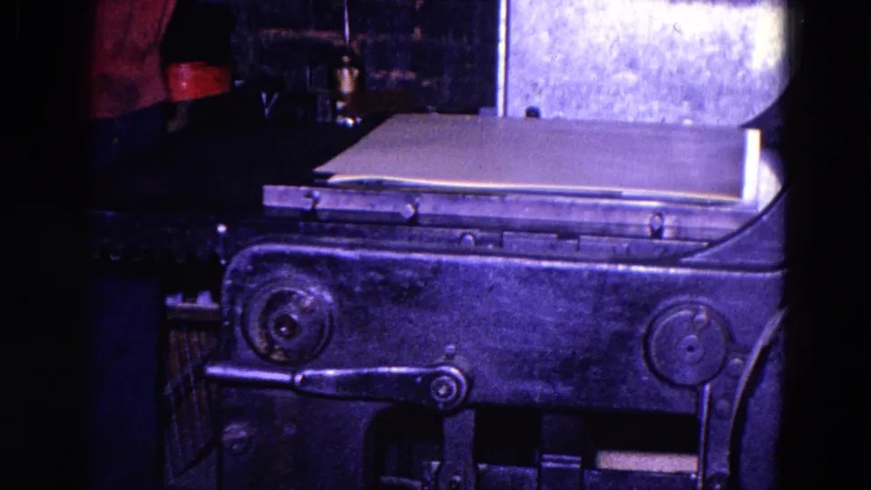 The final frame shows the paper sheet resting on the metal machine while the worker remains mostly cropped from view.