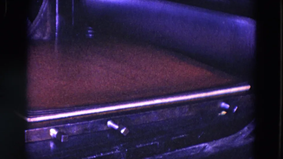 The industrial press surface is shown close up, with flat material and metal edges dominating the 8mm frame.