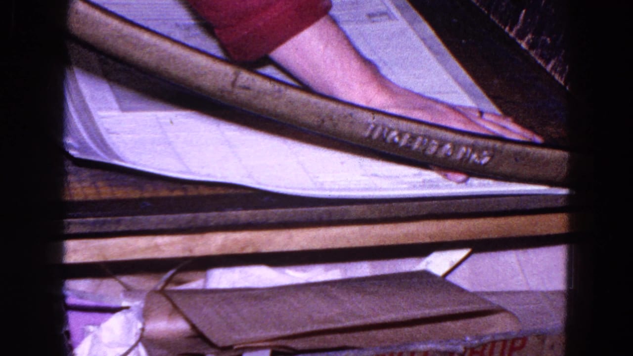 Close view of a large paper cutter table with oversized sheets and a worker's arm nearby.