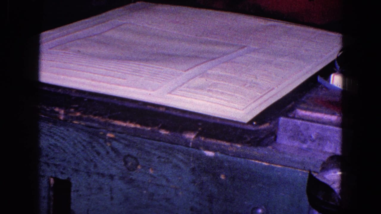 Close 8mm view of the white fabric piece and its folded sections on a dark wooden surface in the Trenton 1967 clip.