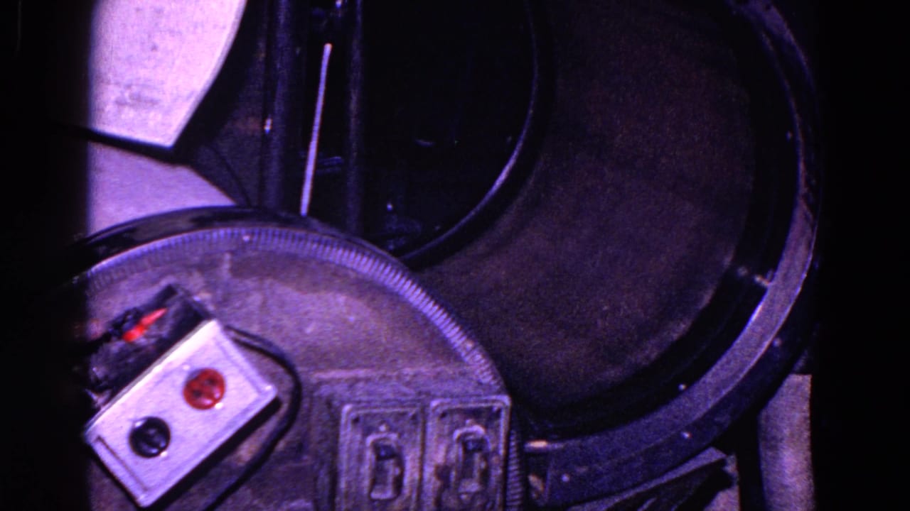 Close view of a cylindrical press mechanism with control buttons and paper partly visible.