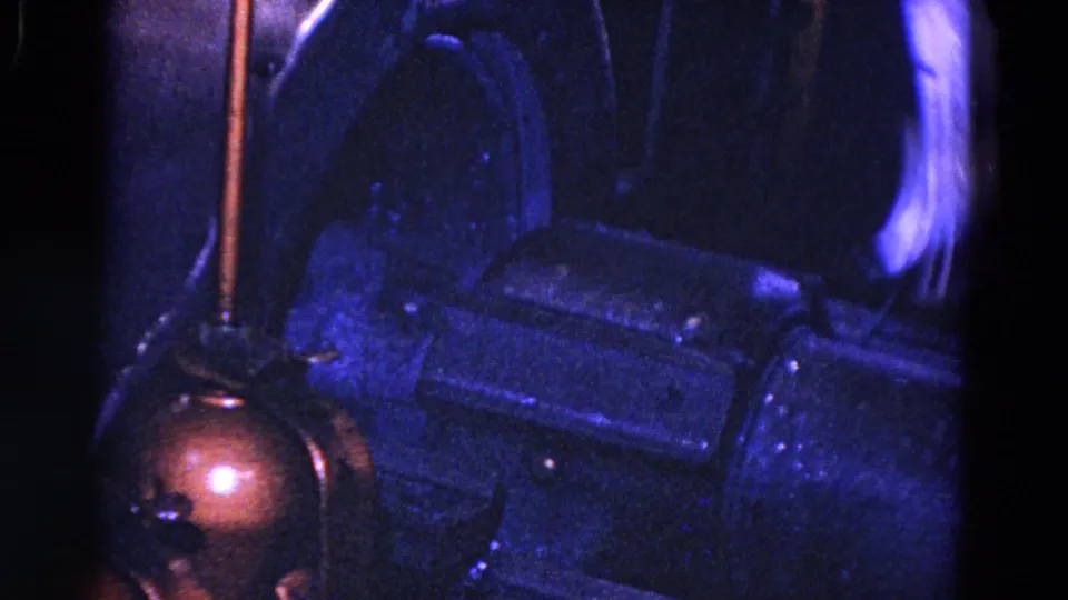 1967 Trenton industrial frame showing dark machine housings, copper tubing, and warm furnace light at lower left.