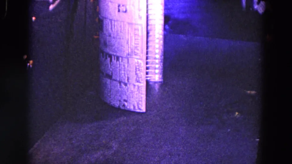 1967 Trenton industrial frame with the corrugated tube centered upright, showing ribbed metal texture and dim workshop lighting.