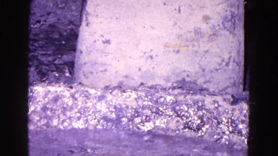 1967 Trenton industrial close-up with a rough mold surface, dark machinery edges, and purple-tinted 8mm film texture.