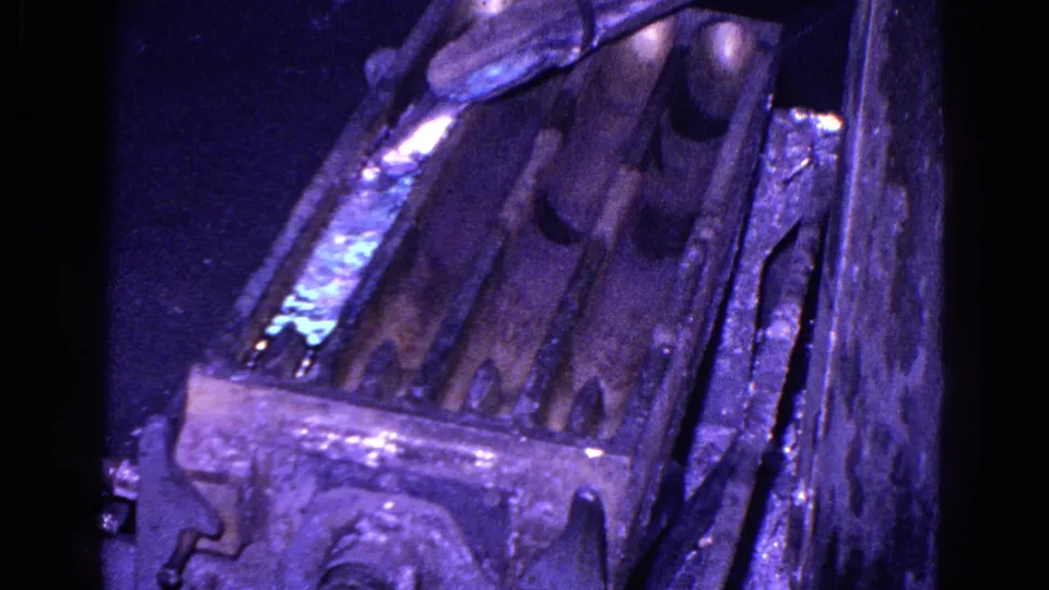 1967 Trenton 8mm frame showing reflective liquid moving along one chute within a worn industrial metal assembly.