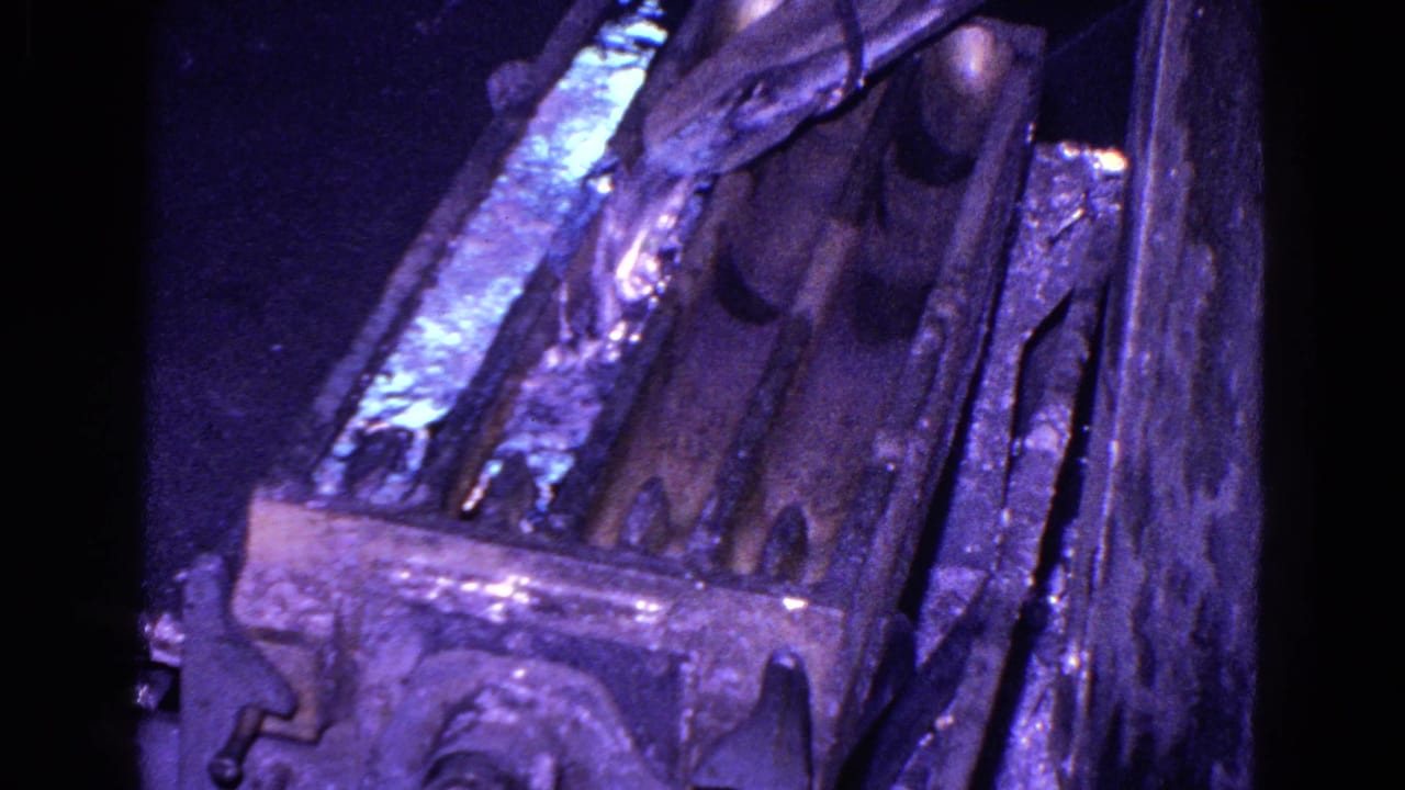 Close 8mm view of industrial molds in Trenton, New Jersey, with bright molten material visible near the top of the frame.