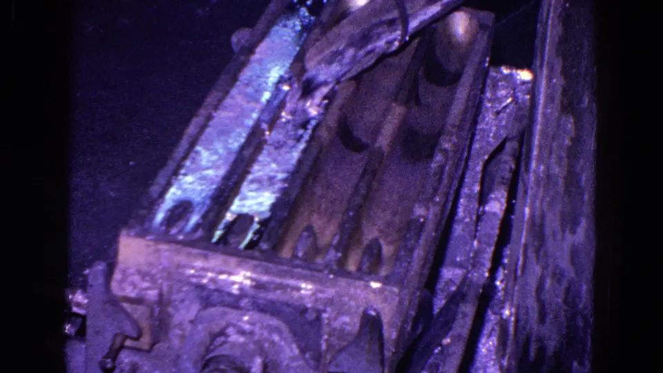 8mm archival frame of a Trenton industrial casting mold, with molten metal glow and dense shadows around the form.