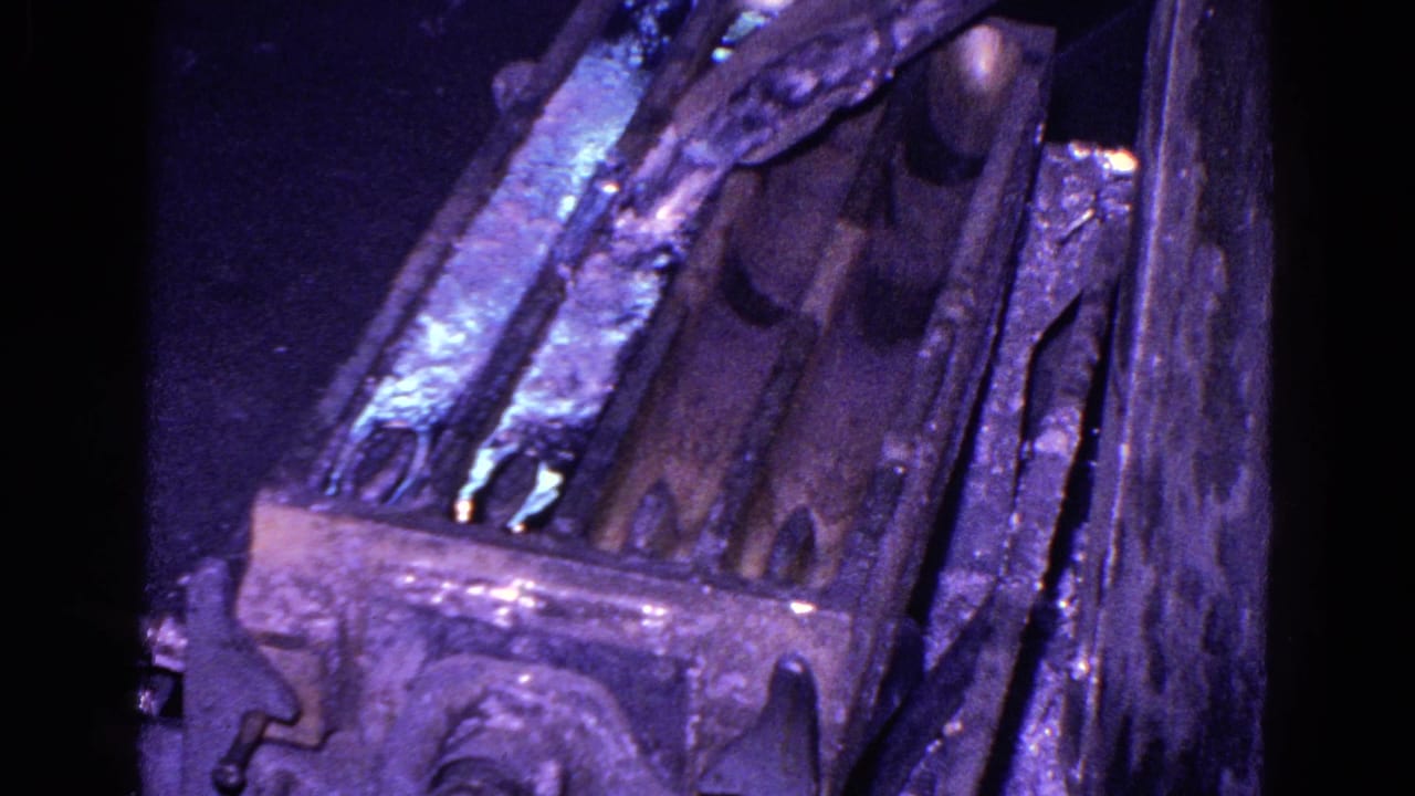 Close view of a metal mold or casting area with reflective purple-blue surfaces.