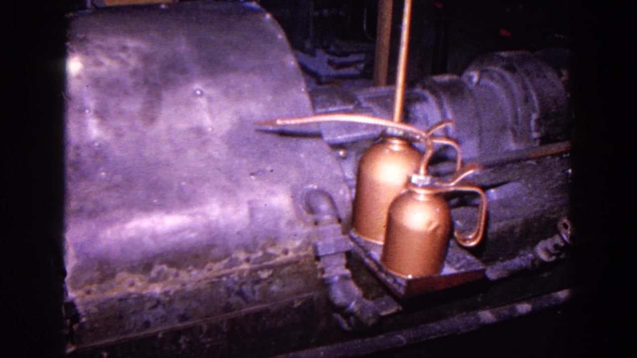 1967 Trenton factory footage showing a dark metal shaping machine with copper oil cans and pipes in close view.