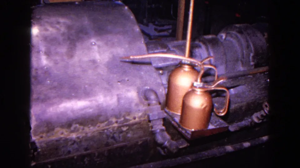 1967 Trenton factory footage showing a dark metal shaping machine with copper oil cans and pipes in close view.