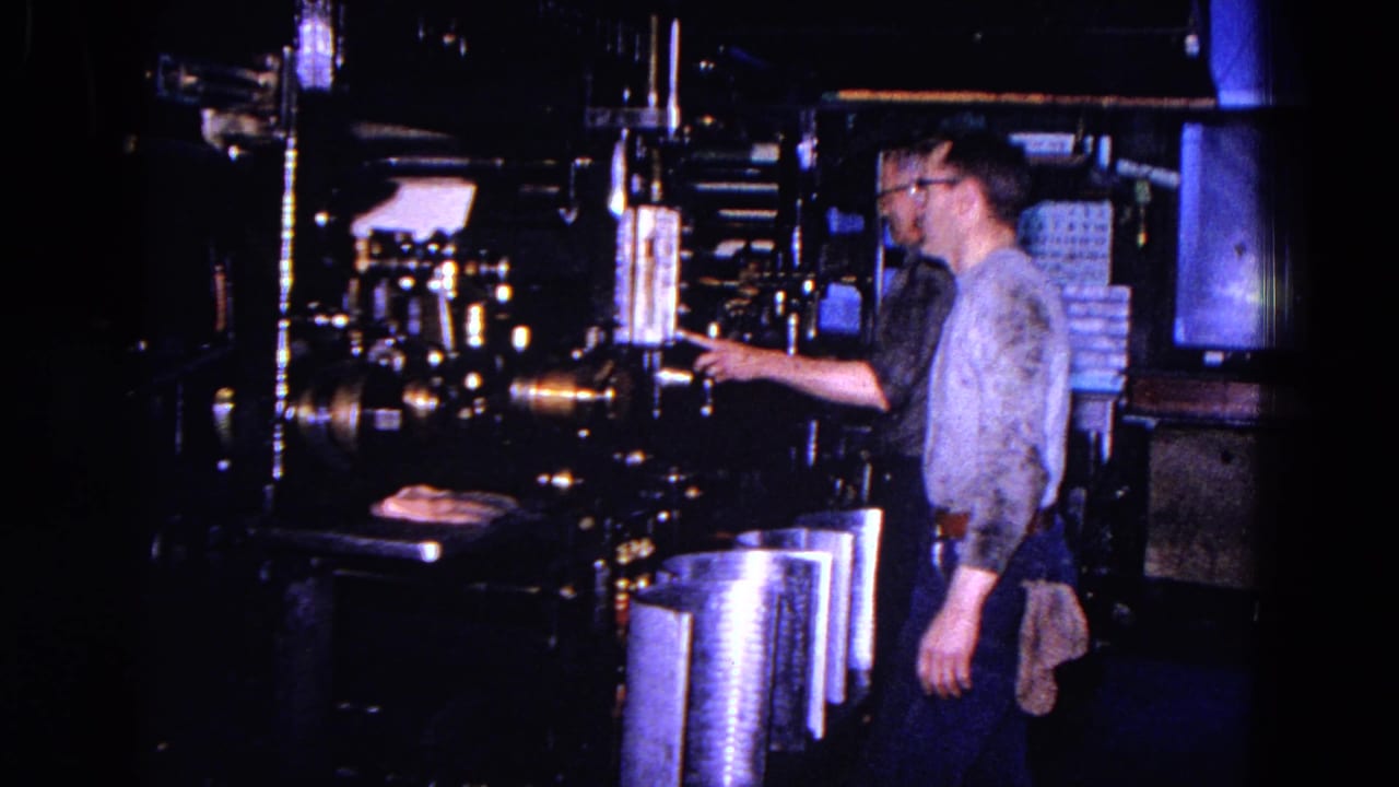 A 1967 home-movie frame shows a worker beside heavy factory machinery and bright metal components in Trenton.