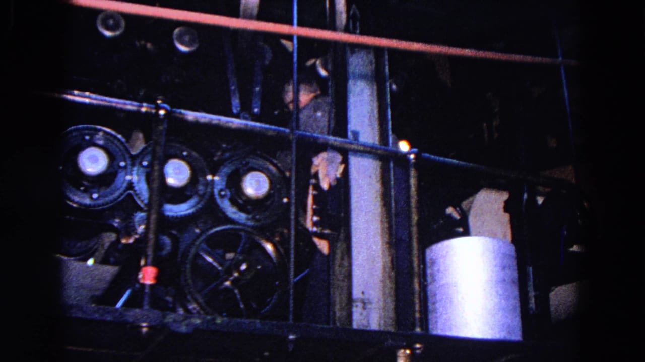 1967 Trenton factory view showing railings, pulleys, pipes, and a partially obscured worker near equipment.