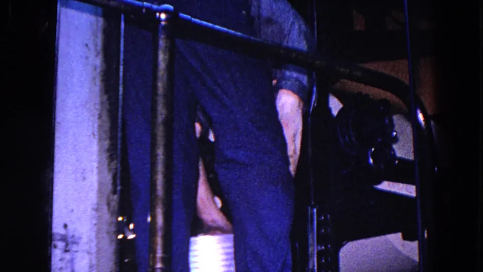 A worker in dark clothing stands close to machinery and railings inside the 1967 Trenton industrial interior.