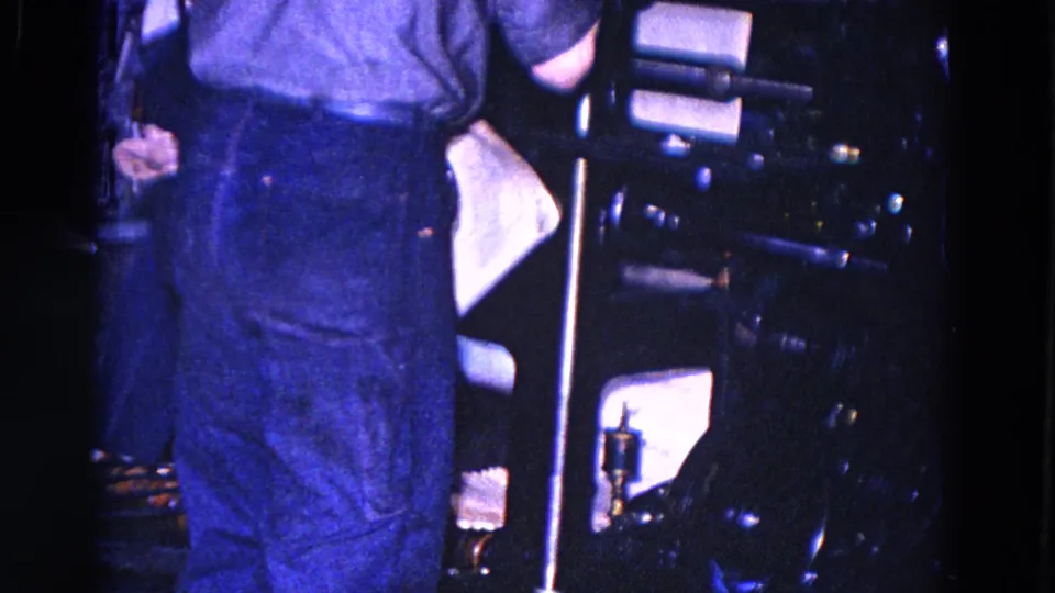 1967 Trenton print-room footage shows a worker beside a large newspaper press in a dim industrial interior.