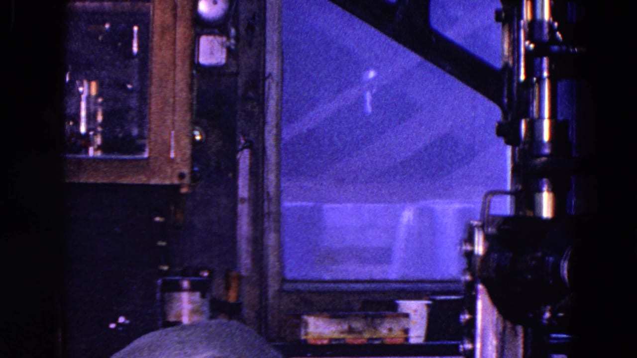 1967 Trenton interior frame showing a dark room with a window, cabinet, fixtures, and a newspaper edge in the foreground.
