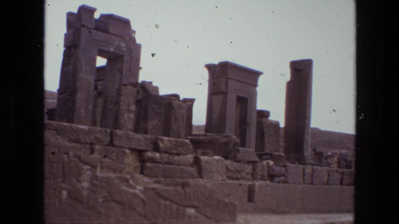 Stone ruins with a tall column, block walls, relief carving, and doorway structures.