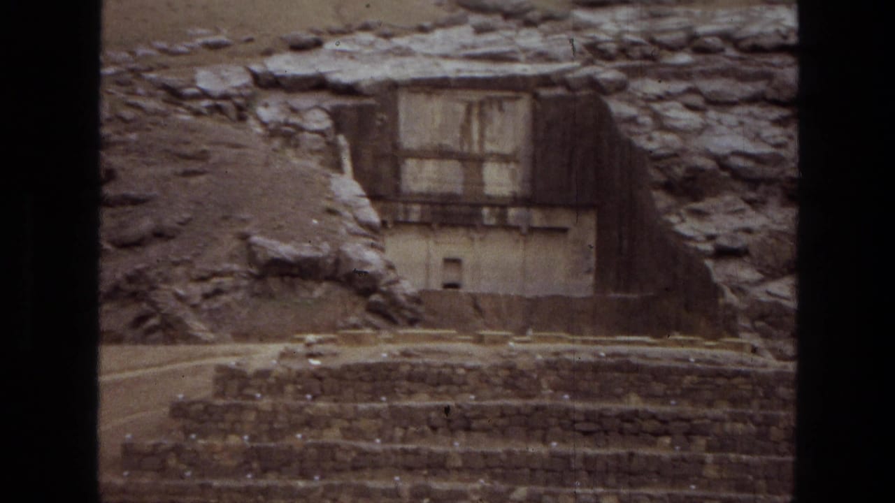 Rock-cut stone facade above stepped platforms in a dry ruin site.