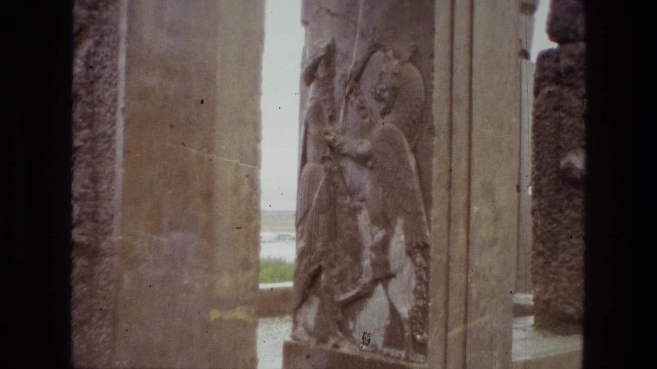 Stone pillars with a carved winged figure relief, seen through dark 8mm frame borders.