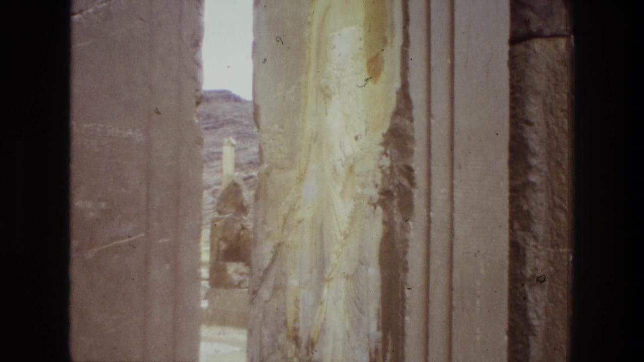 A steady 8mm view in Iran shows corroded stonework, vertical pillar edges, and rocky desert terrain in the distance.