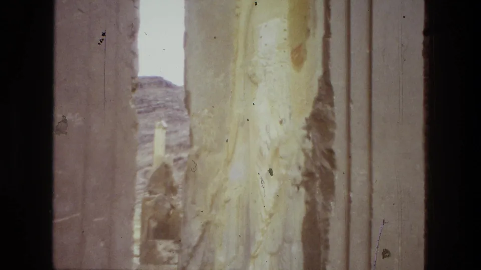 Close 1972 8mm view of stained ancient-looking stonework in Iran, with a small opening toward the rocky landscape.