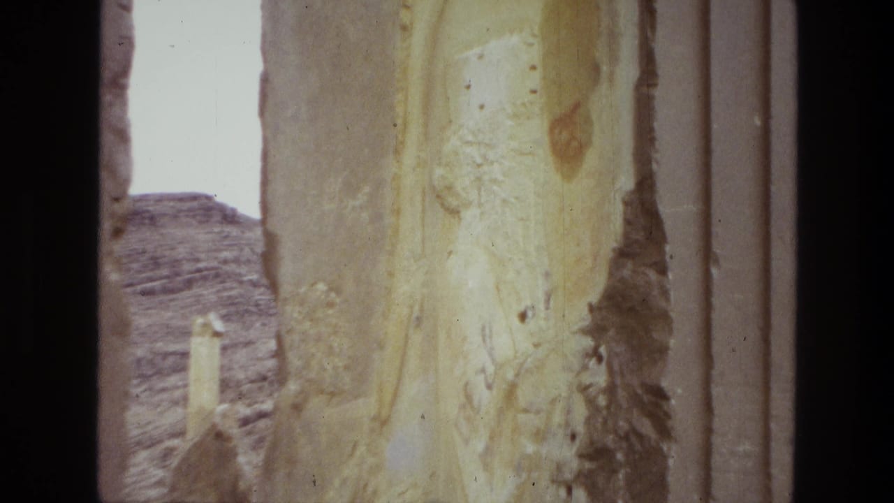 Close view of a weathered stone column with desert hills beyond.
