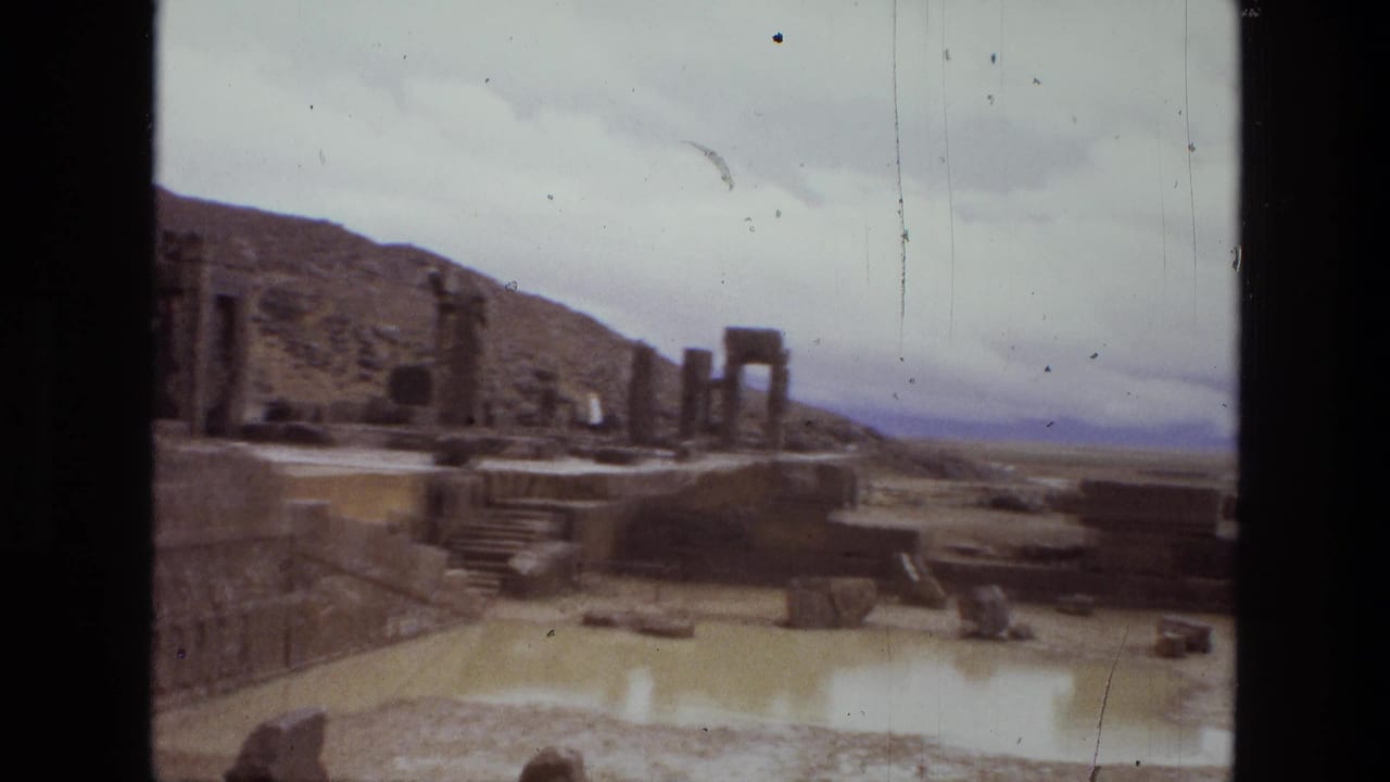 Ruined stone terraces, columns, steps, and scattered blocks in a dry landscape.