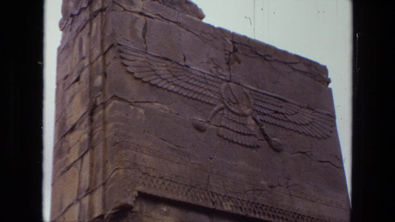 Close view of a weathered stone monument with a carved winged symbol.