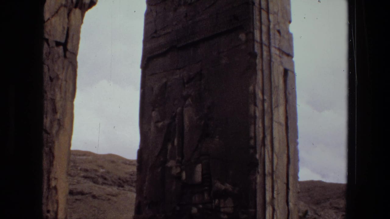 Close view of a weathered stone doorway or monument block with hills behind it.