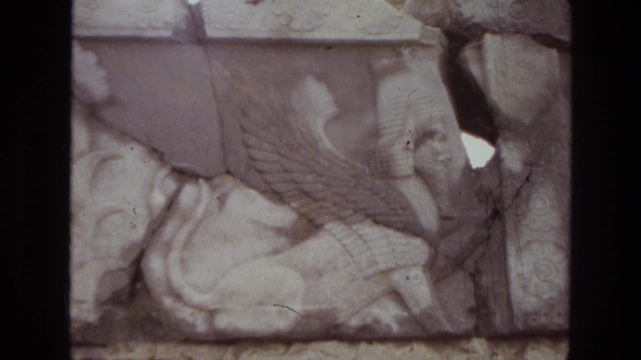 1972 Iran frame with a close view of a pale stone winged creature relief, framed by dark film edges and visible film wear.