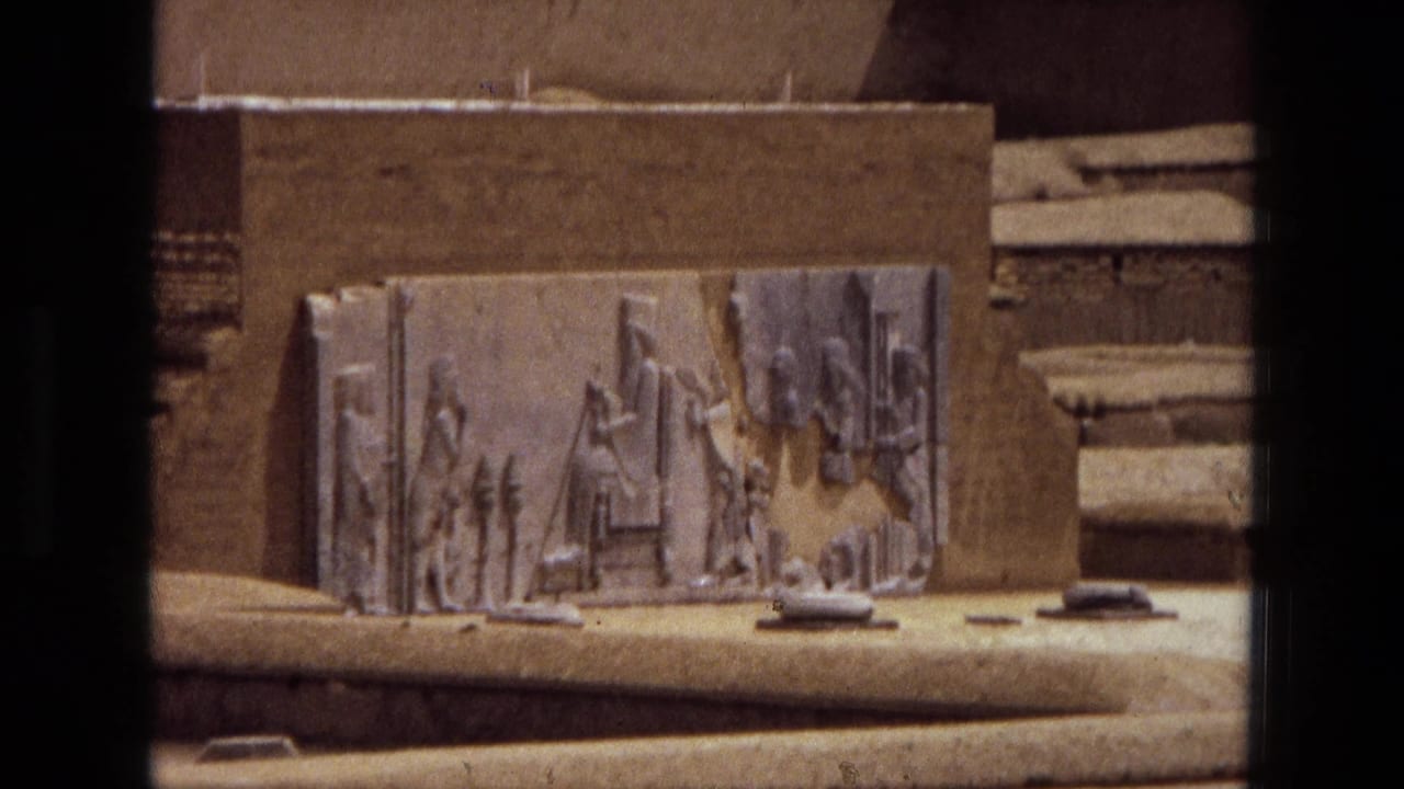 Closer view of the carved relief panel against a sandy wall with steps visible to the side.