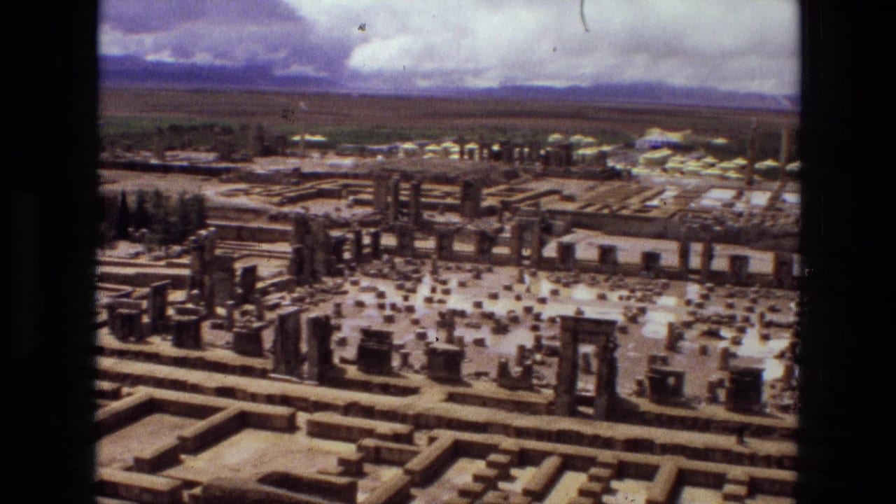 Aerial view over stone foundations, columns, and scattered ruins in an open landscape.