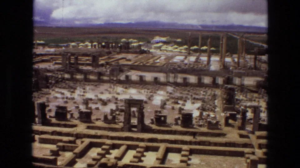 Aerial 1972 Iran footage, likely over Persepolis, with columns, carved stone remains, tents, and vehicles near the site.
