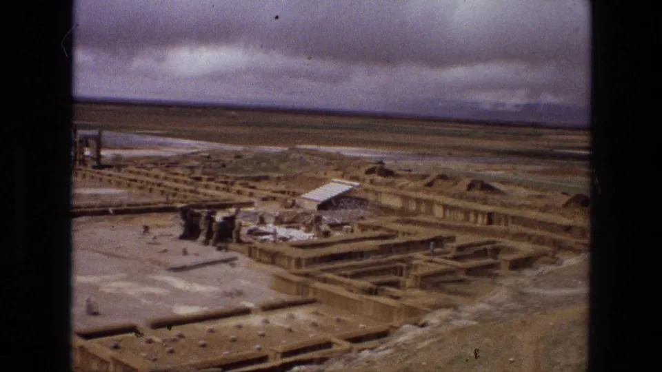 1972 Iran 8mm aerial frame looking across low archaeological foundations, scattered masonry, and desert terrain.