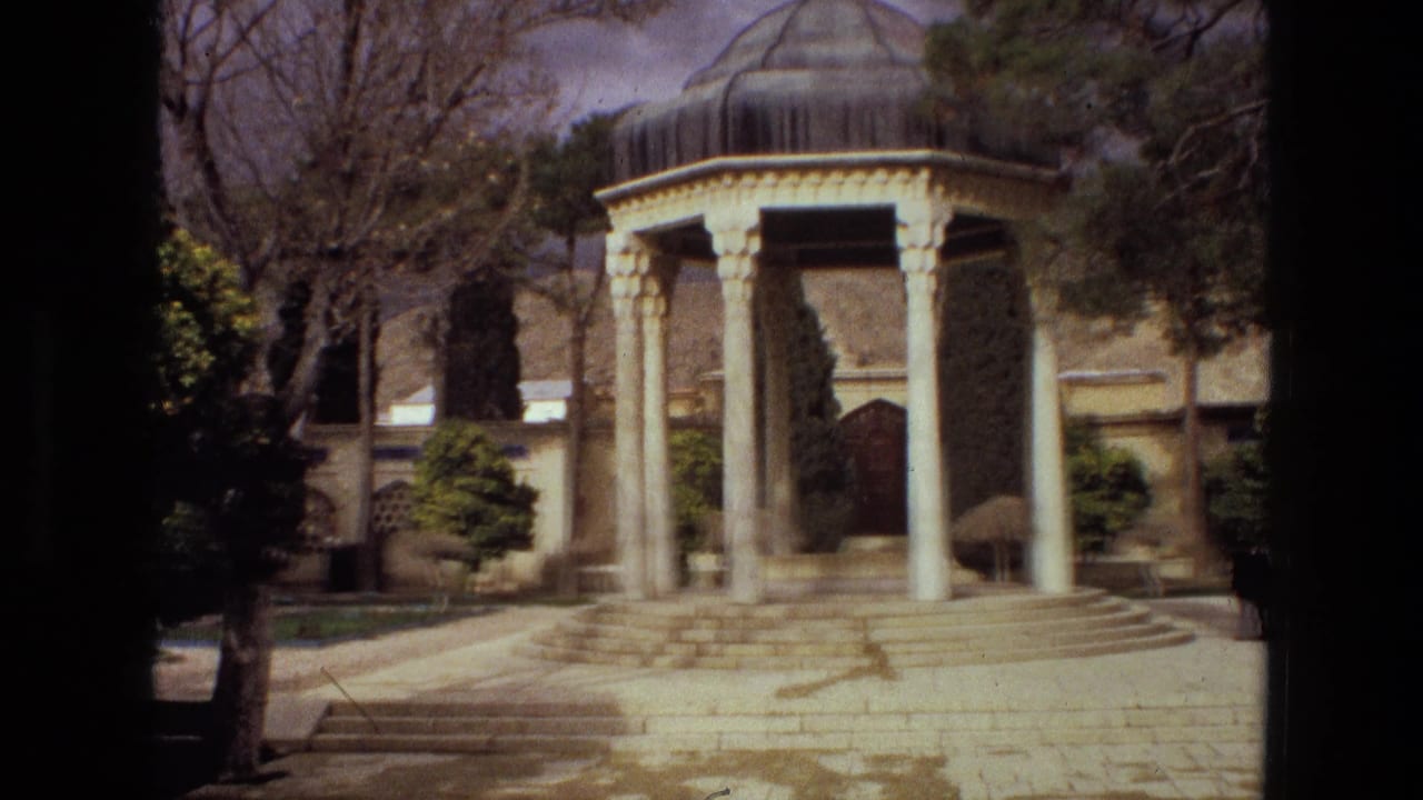 1972 Iran home-movie frame of a historic-looking domed pavilion, framed by trees and a low garden wall.