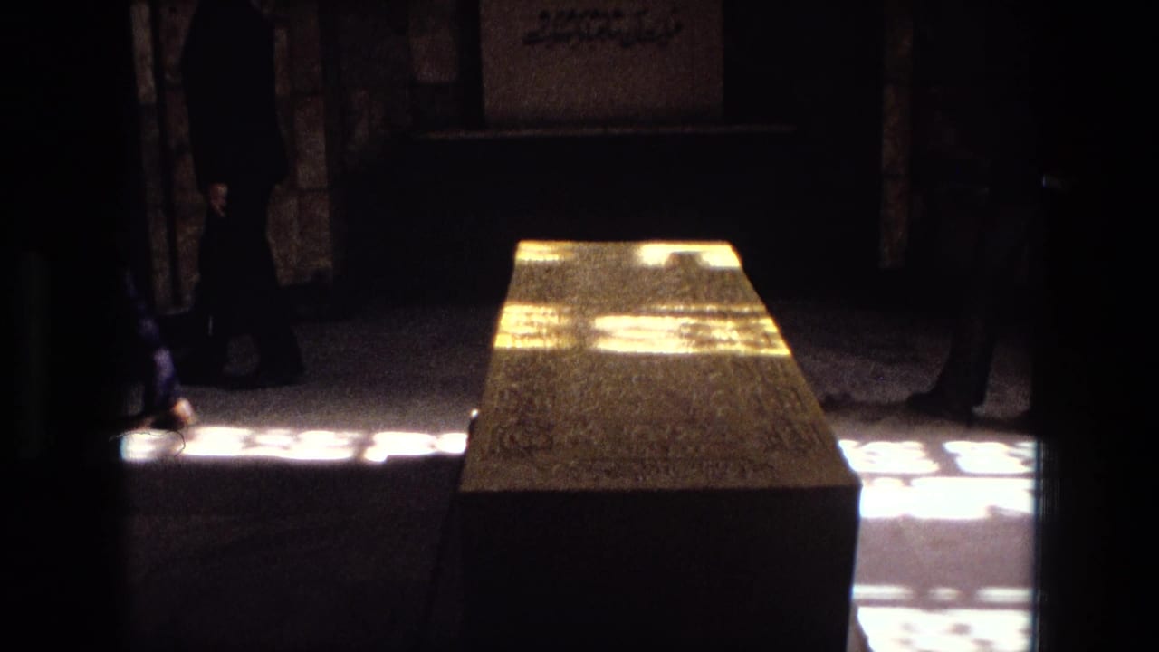 Stone tomb and silhouetted visitors inside a dark interior with bright window light.