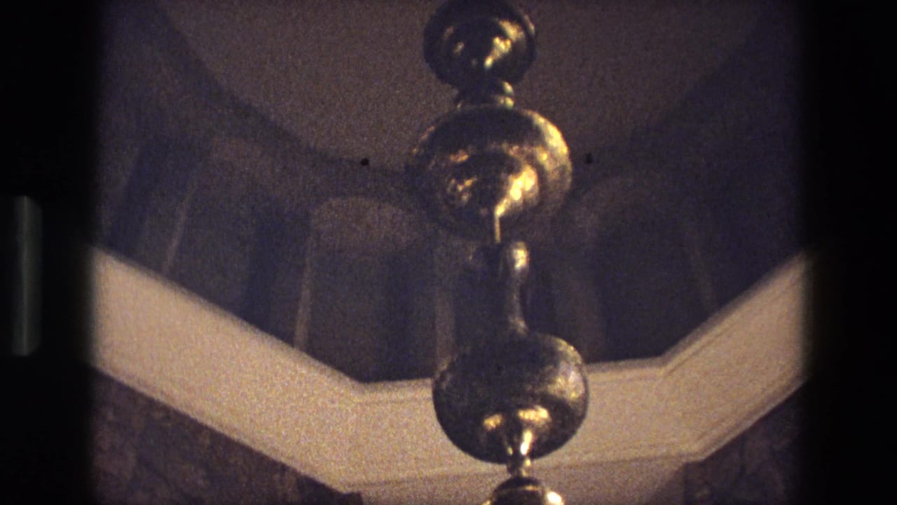 Gold hanging fixture below a dim domed ceiling.
