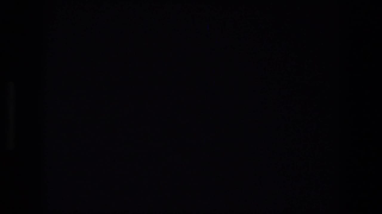 Dark 8mm frame with minimal visible detail, suggesting an in-camera transition, obstruction, or underexposed moment.