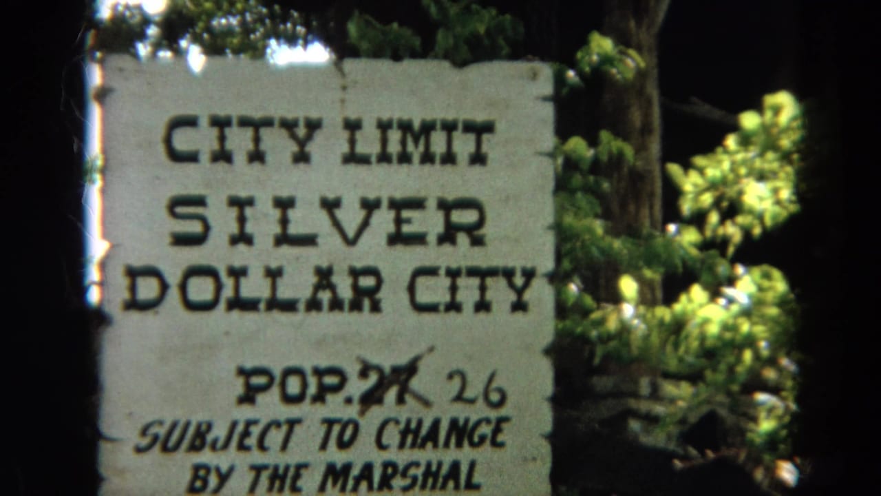 Silver Dollar City sign fills the frame with green leaves and dark film border visible.