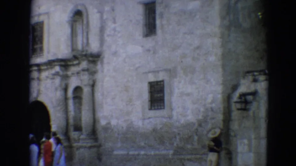 Tourists in 1968 Branson appear near a mission-style stone entrance, with barred windows and rough wall texture visible.