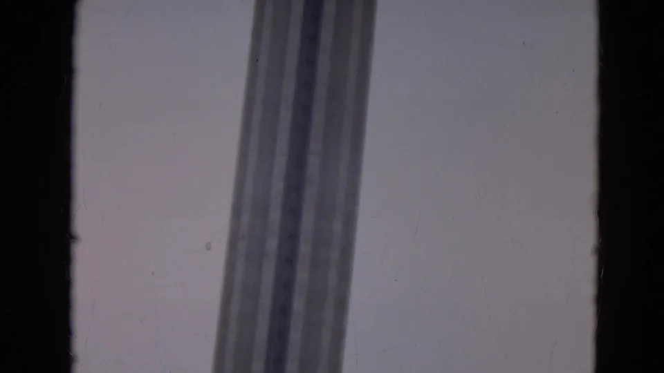 The Space Needle support columns rise through a low-angle 8mm frame with visible film grain and edge darkness.