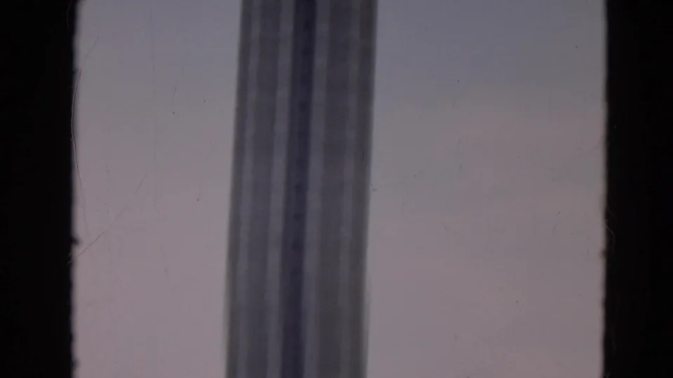 1968 Branson 8mm frame showing a tall vertical windowed structure seen through a dark interior window frame.