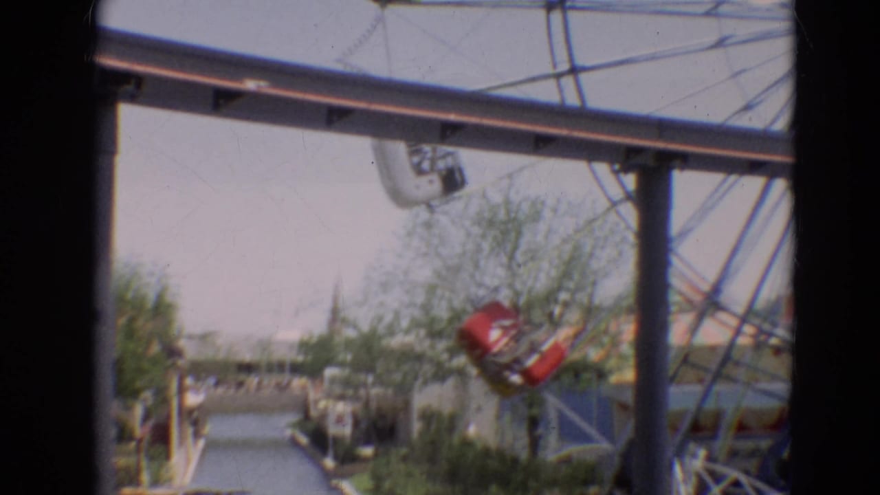 1968 Branson carnival view showing a red Ferris wheel car near overhead supports and a water ride channel in the foreground.