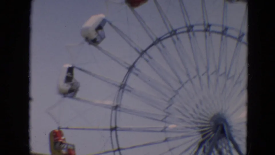 Ferris wheel at the Branson carnival in 1968, with small red and white gondolas visible against a pale sky.