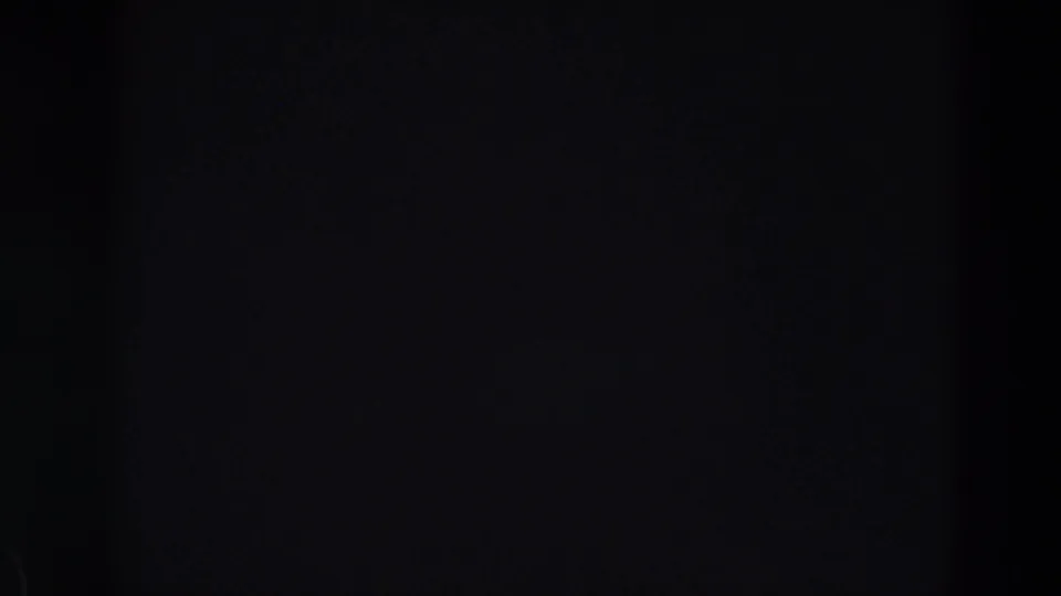Dark 8mm home-movie frame with faint exposure variation and no identifiable people, signage, or ride details visible.