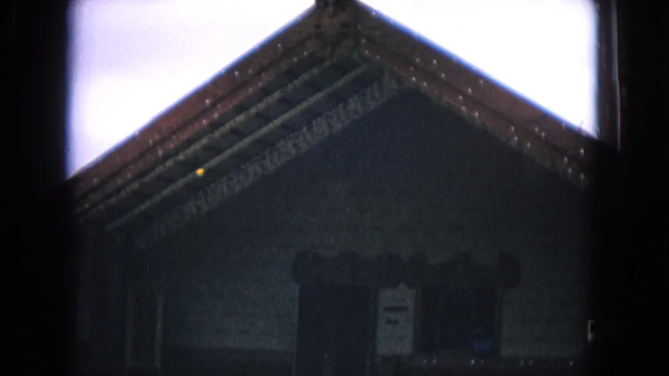 1968 Honolulu 8mm frame with a closer, underexposed view of the gabled roof, carved edge details, and central entrance.