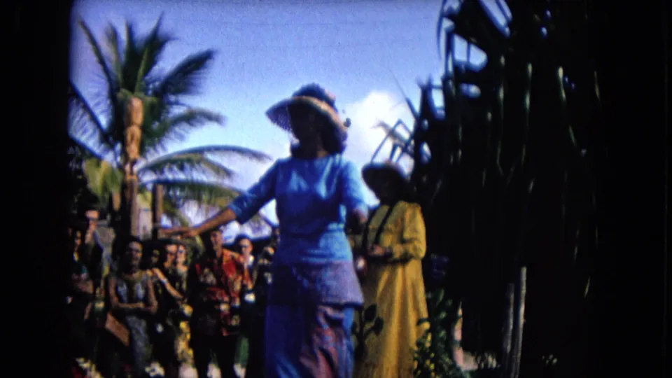 Visitor-shot 1968 Honolulu hula performance with the main dancer in blue moving across the frame before a seated audience.