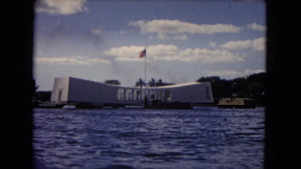 Wide 8mm frame of the USS Arizona Memorial in Pearl Harbor, seen from a moving boat in Honolulu.