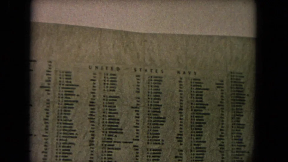 1968 Honolulu home-movie frame showing columns of U.S. Navy names on the U.S.S. Arizona Memorial wall.