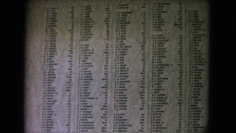 Close 1968 Honolulu home-movie view of names arranged in columns on a memorial wall, framed by dark 8mm film edges.
